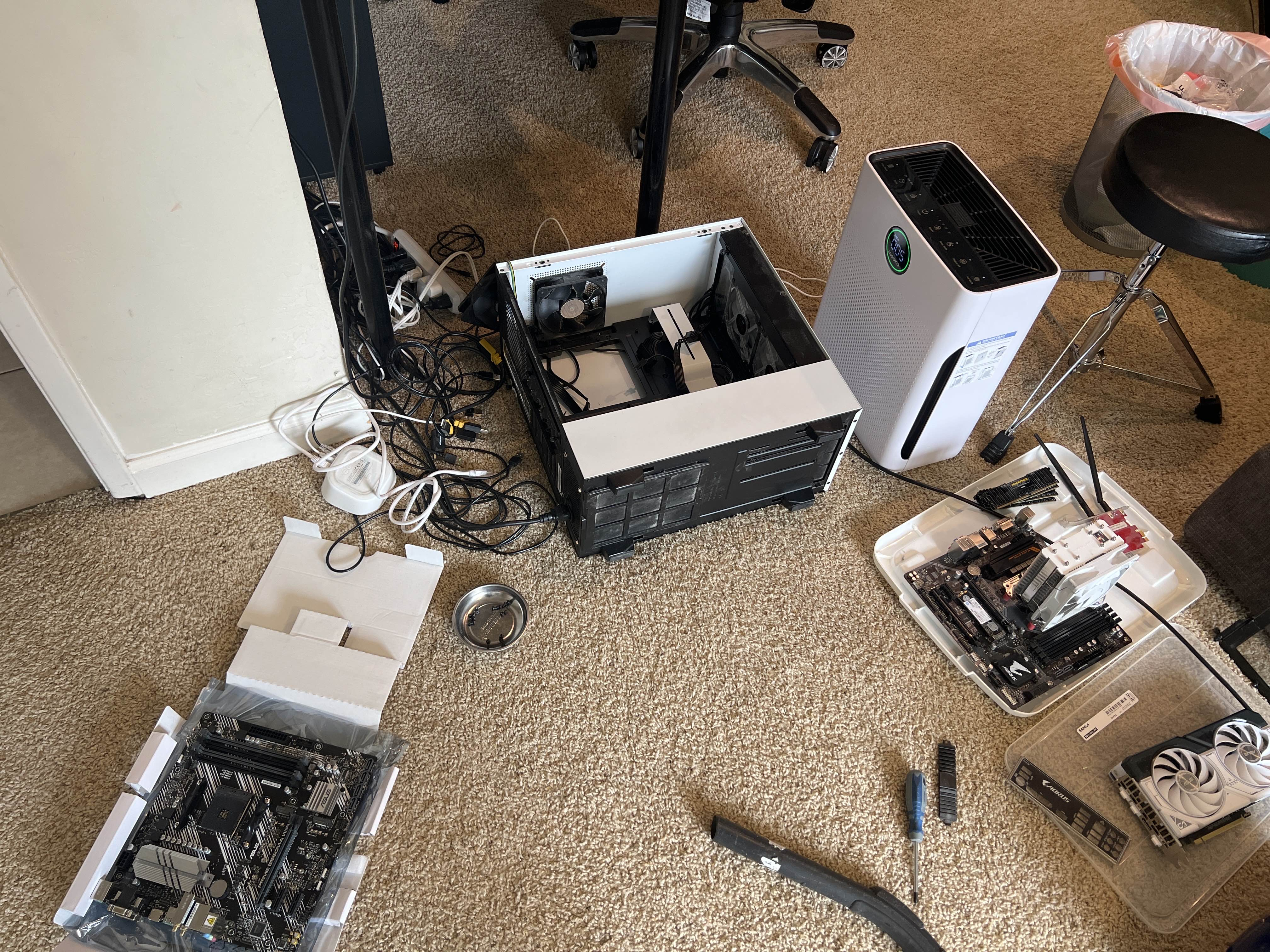 PC build in progress: case, motherboards and parts laid out on the floor